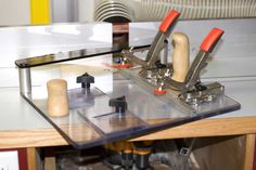 a machine that is sitting on top of a table next to a piece of wood