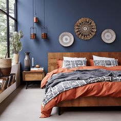 a bedroom with blue walls and orange bedding