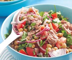 a blue bowl filled with meat and veggies next to another bowl full of salad