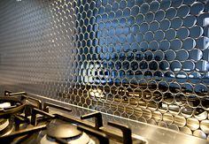 a stove top oven sitting inside of a kitchen next to a metal grill cover over it's burners