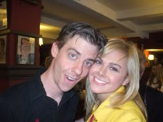 a man and woman are posing for a picture in front of the camera at a restaurant