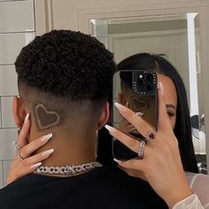 a woman taking a selfie in front of a mirror with a man's face drawn on it