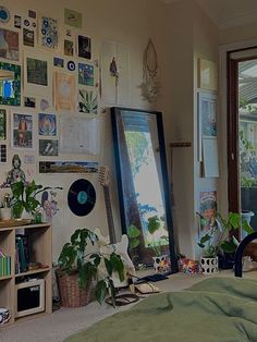 a bedroom with lots of plants and pictures on the wall