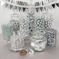 there are many different types of candies in the glass vases on the table