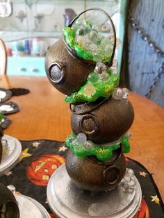 a stack of rocks sitting on top of a table covered in green and white decorations