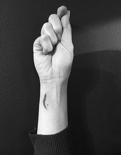 a black and white photo of a person's arm with a tattoo on it