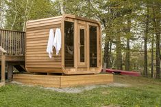 a hot tub sitting on top of a wooden deck next to a tree filled forest