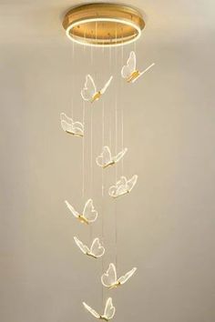 a chandelier with white butterflies hanging from it's sides in a room