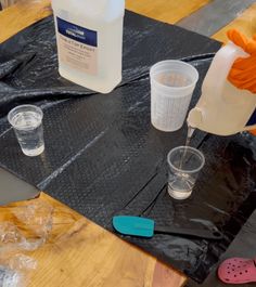 the table is covered with plastic cups and other items to make a diy project