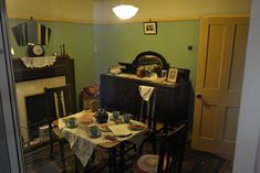 a dining room table with plates and cups on it in front of a fire place