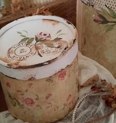 an old tin can sitting on top of a table next to a flowered cloth