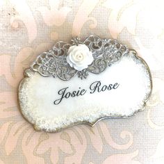 a brooch with the name josie rose on it and a flower in the center