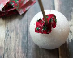 an ornament with a red bow on it sitting on top of a wooden table