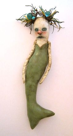 a green mermaid doll hanging on the wall