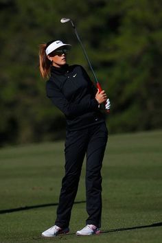 a woman is playing golf on the green