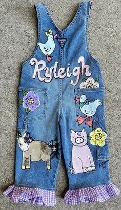 a pair of blue jean shorts with farm animals on them and the words rideign