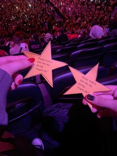 two people holding up stars in front of an audience