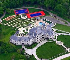 an aerial view of a large mansion with tennis courts