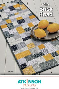 a table runner with three lemons on it and the words, mini brick road