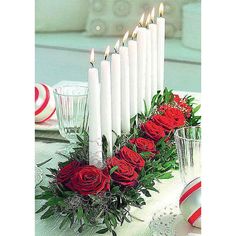 a table topped with candles and flowers on top of a white table covered in candy canes