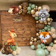 an assortment of balloons and decorations for a baby's first birthday with woodland animals