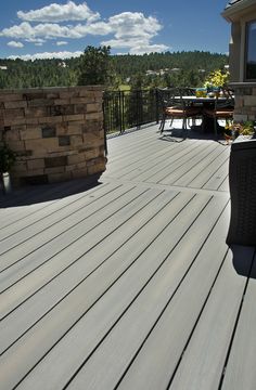 an outdoor deck with chairs and table on it