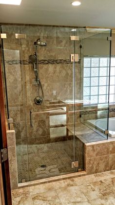 a walk in shower sitting next to a bath tub