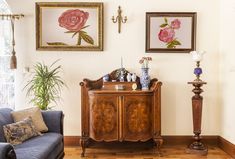 a living room filled with furniture and paintings on the wall