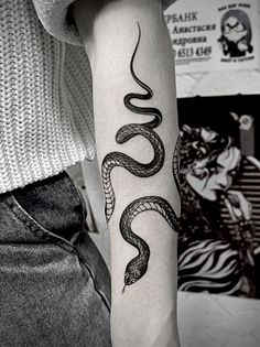 a woman's arm with a snake tattoo on it