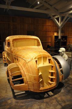 a car made out of wood sitting in a garage