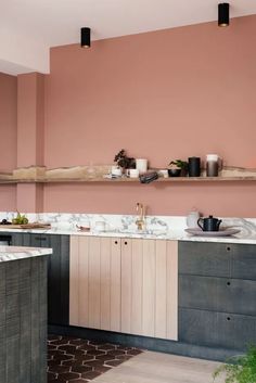 a kitchen with pink walls and marble counter tops