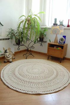 a living room with a round rug on the floor and potted plants next to it