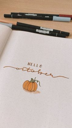 an open notebook with the words hello october written in cursive writing on it