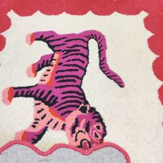 a pink and white rug with an image of a tiger on it's back