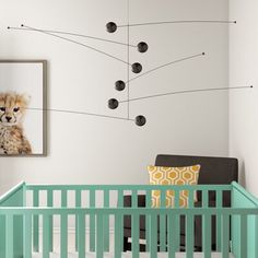 a baby's room with a green crib and pictures on the wall