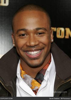 a smiling man in a leather jacket and tie