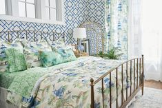 a bed in a bedroom with blue and green wallpaper