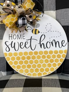 a sign that says home sweet home with a bee and honeycomb design on it