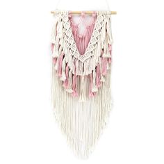 a pink and white wall hanging with tasselled fringes on a wooden hanger