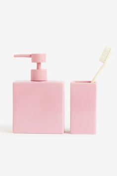 a pink soap dispenser and toothbrush holder on a white background,