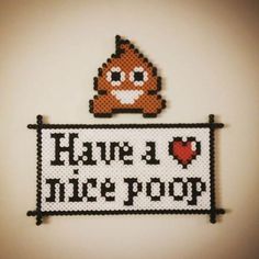 there is a cross stitch sign that says have a nice poop with a smiling face on it