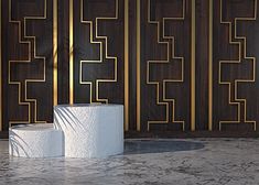 a white toilet sitting on top of a marble floor next to a wall with gold lines