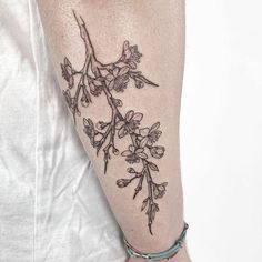 a woman's arm with flowers on it and a tattoo design on the wrist