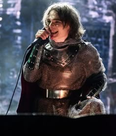 a man in armor singing into a microphone