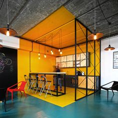 an open concept kitchen and dining area with yellow walls, black accents and white ceilinging