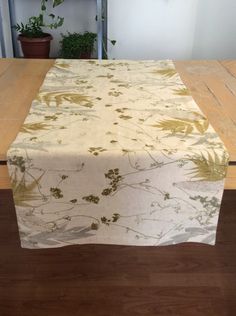 the table is covered with a white and gold floral print fabric, along with a potted plant