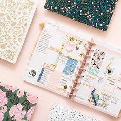 the contents of a planner spread out on a pink surface with flowers and other items