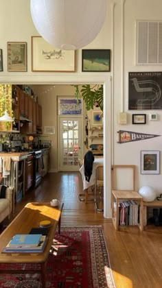 a living room filled with furniture and lots of pictures on the wall next to a coffee table