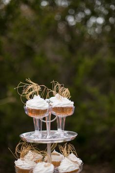 three cupcakes are stacked on top of each other in clear cups with gold straw garnishes