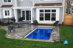 a backyard with a pool and patio furniture